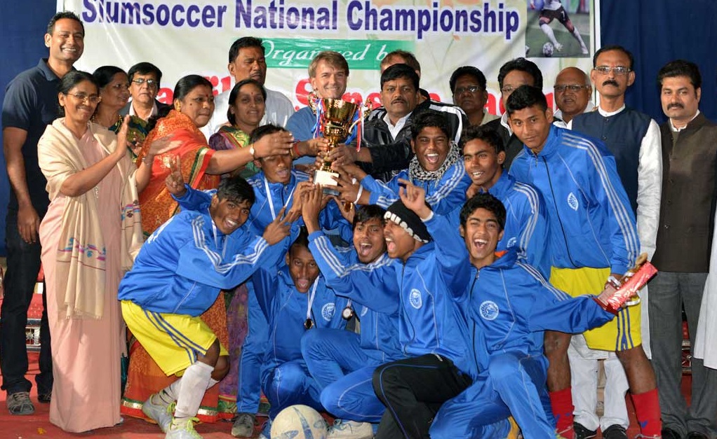 Abhjeet posa com seu pai e o time vencedor do campeonato nacional de Slum Soccer (Slum Soccer/Divulgação)